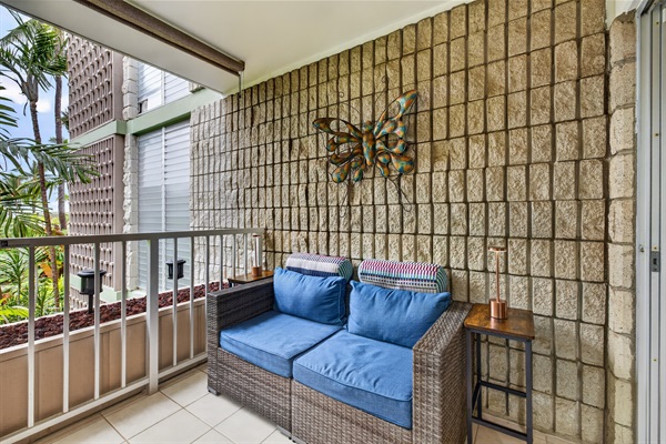 Cozy outdoor loveseat tucked along the lanai—ideal for unwinding with a drink or enjoying a peaceful, romantic evening for two.