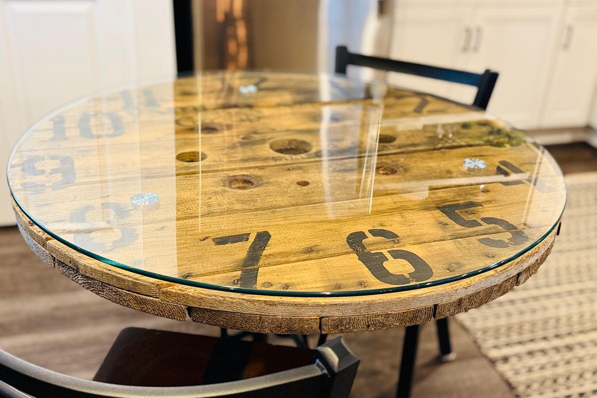 Distinctive industrial clock-wheel table provides space for dining or working.