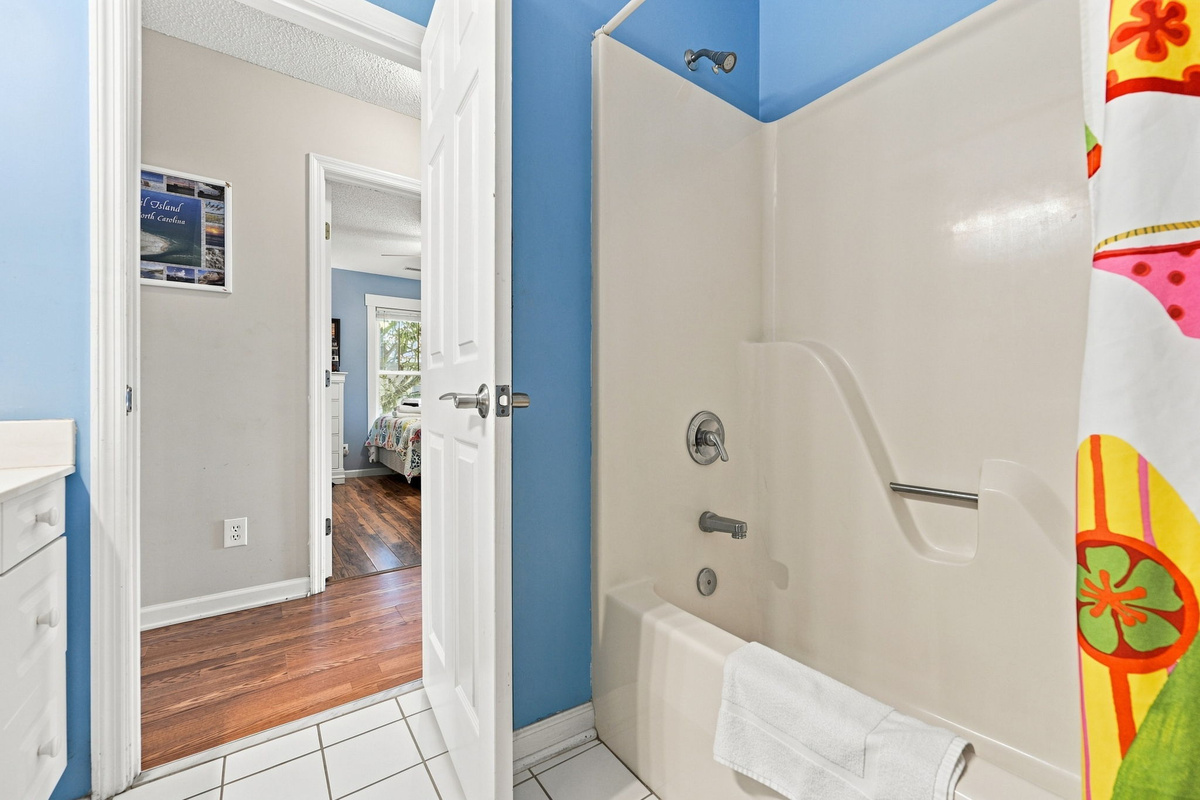 Full bathtub and shower combination, ideal for rinsing off after beach days or relaxing in the evening