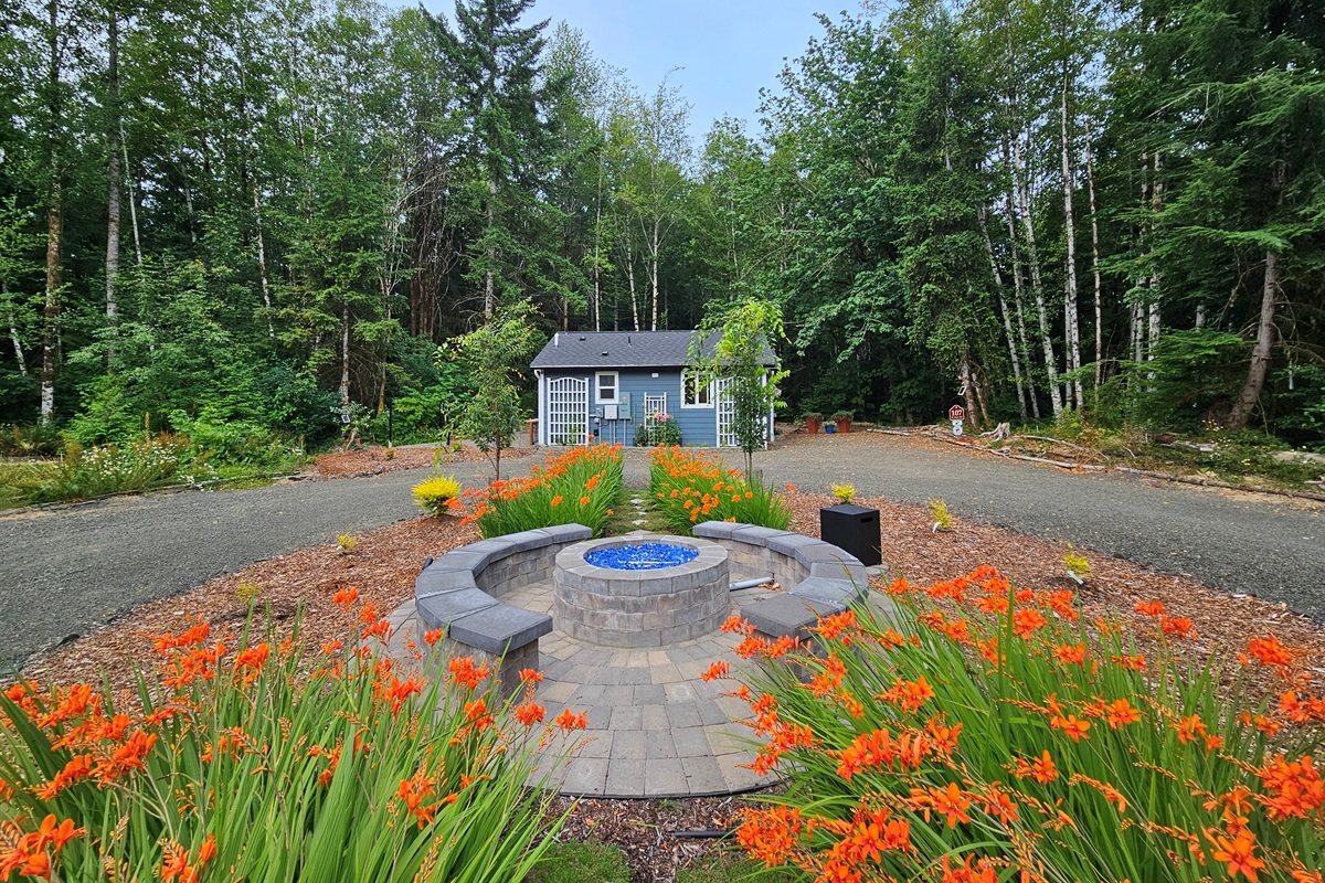 Propane fire pit and seating area between the 105-RV Site and 107-Cottage