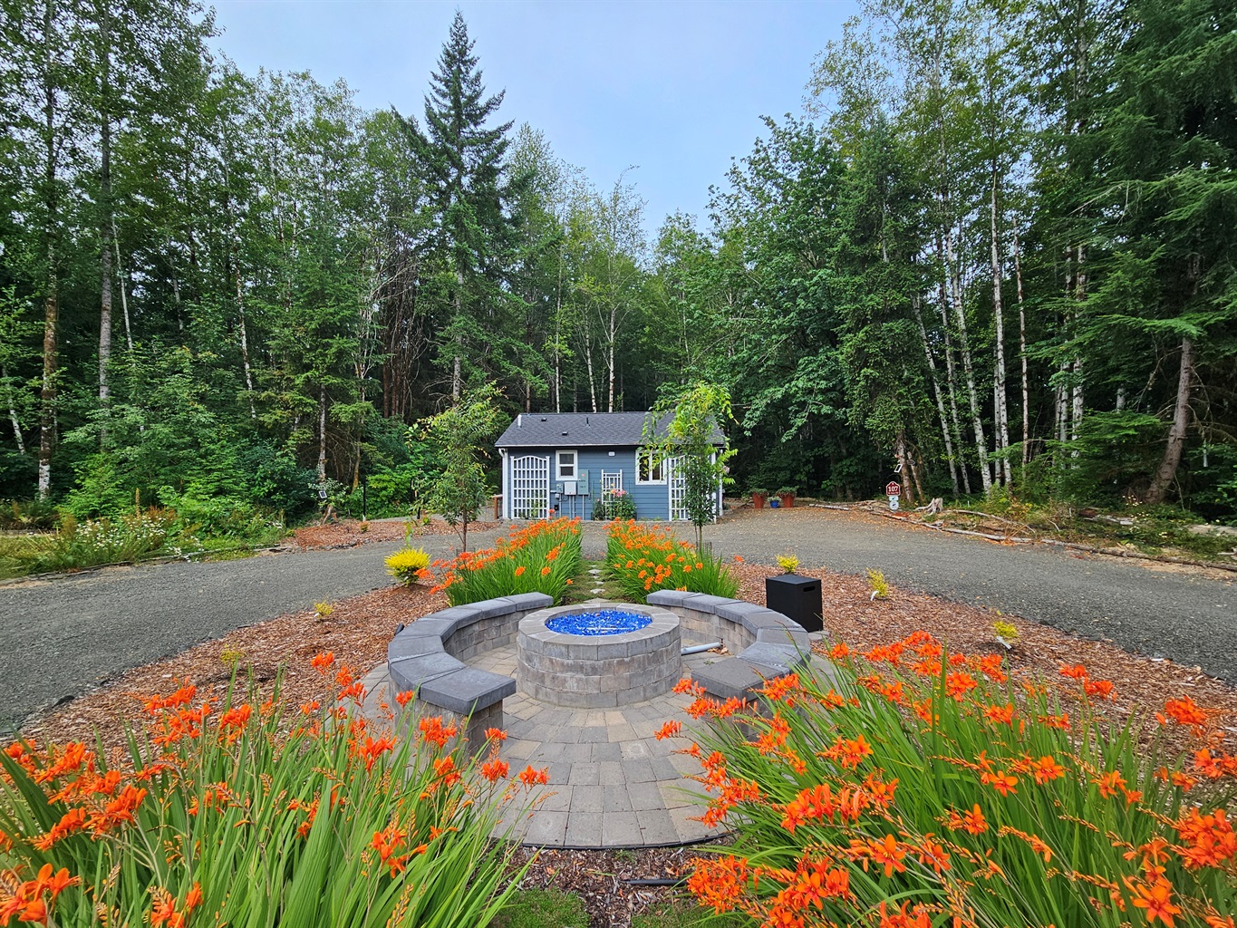 Propane fire pit and seating area between the 105-RV Site and 107-Cottage