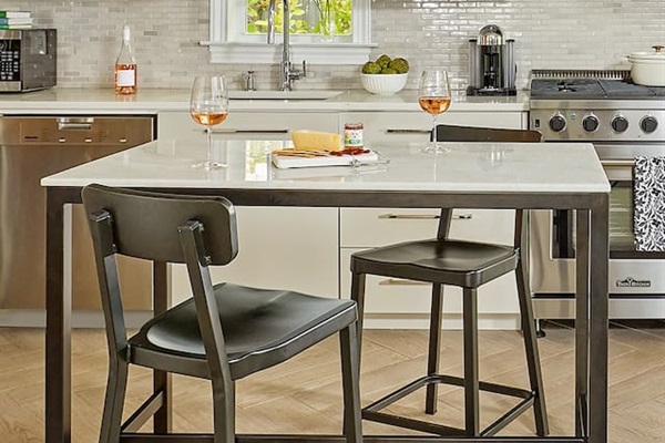 Cook like a pro in a stunning chef’s kitchen, featuring a spacious island perfect for dining or extra prep, quartz countertops, professional Thor gas range, Liebherr refrigerator w/ built-in ice maker, Miele dishwasher, and Nespresso coffee machine.