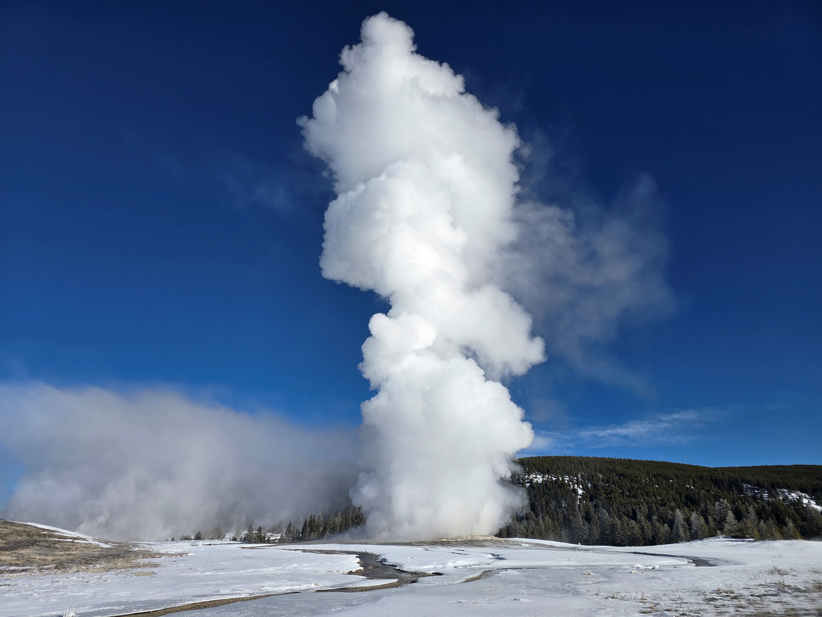 Winter's quiet amplifies the power of Old Faithful, erupting through snow and mist. After a day of exploring the park's wonders, gather at the Lodge for a cozy night by the fire in your home away from home.