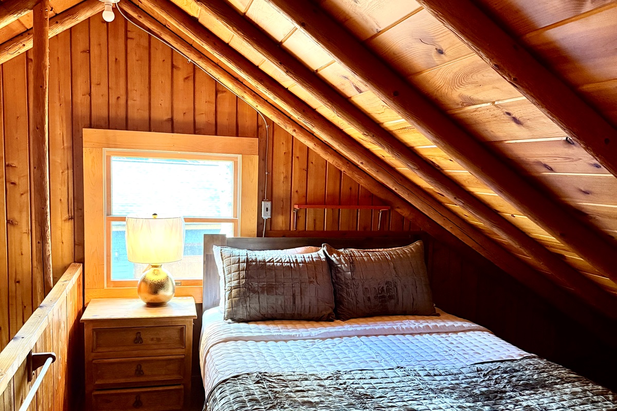 The second bedroom upstairs has a queen bed and also room for storage.