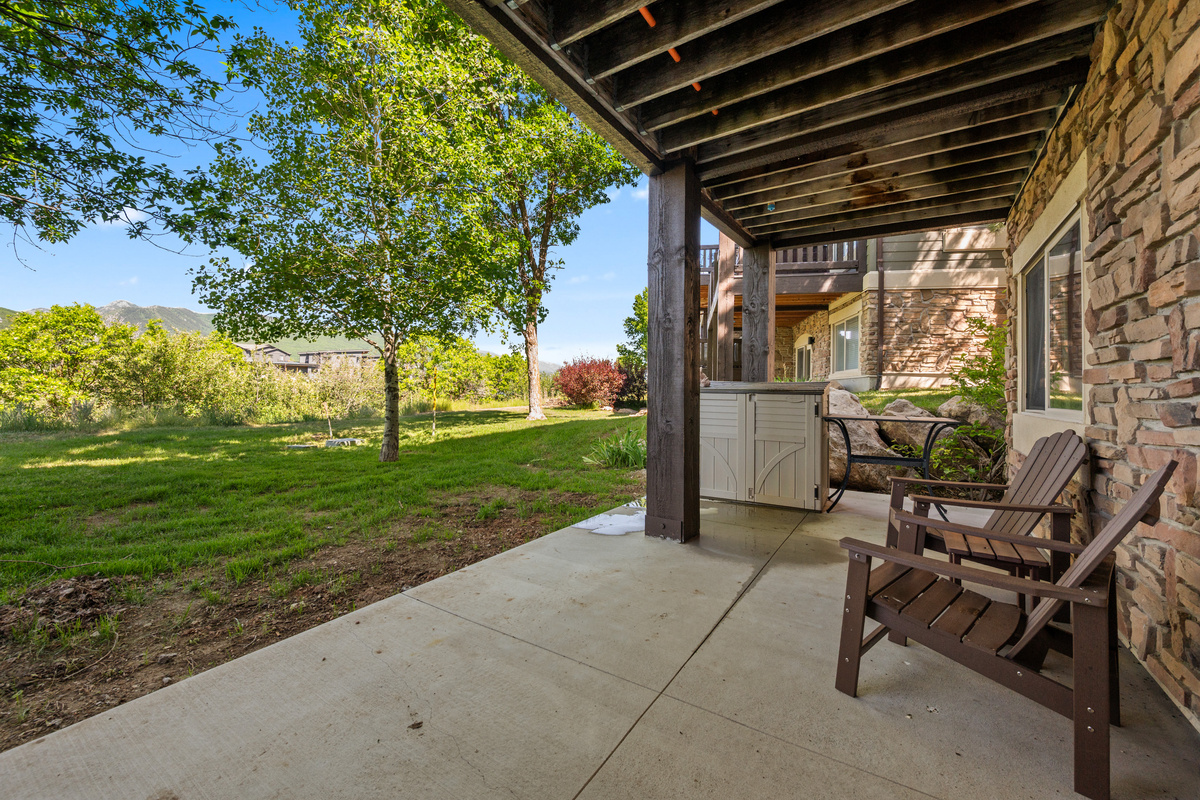 Enjoy the shaded patio with comfortable seating and easy access to the grassy outdoor area — a perfect spot for morning coffee or evening relaxation.