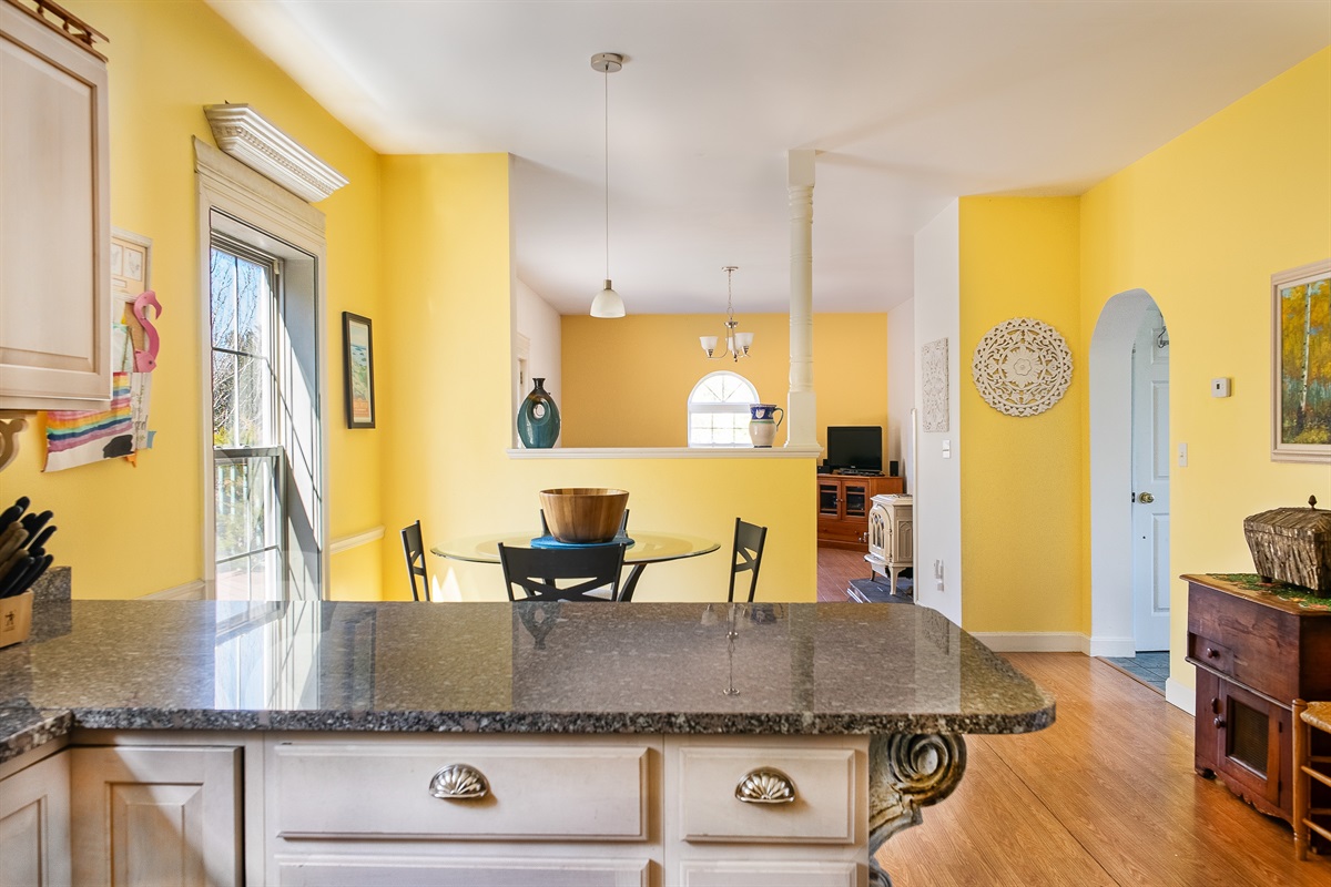 Experience the open-concept design of Seven Peaks Ridge. This view from the kitchen through the breakfast nook into the main living room ensures the group stays connected, whether you're grabbing a quick bite or relaxing after a day in Acadia.