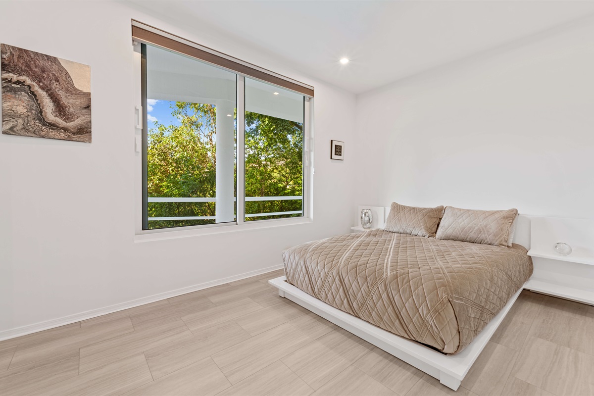 A queen sized bed and large windows in the guest room