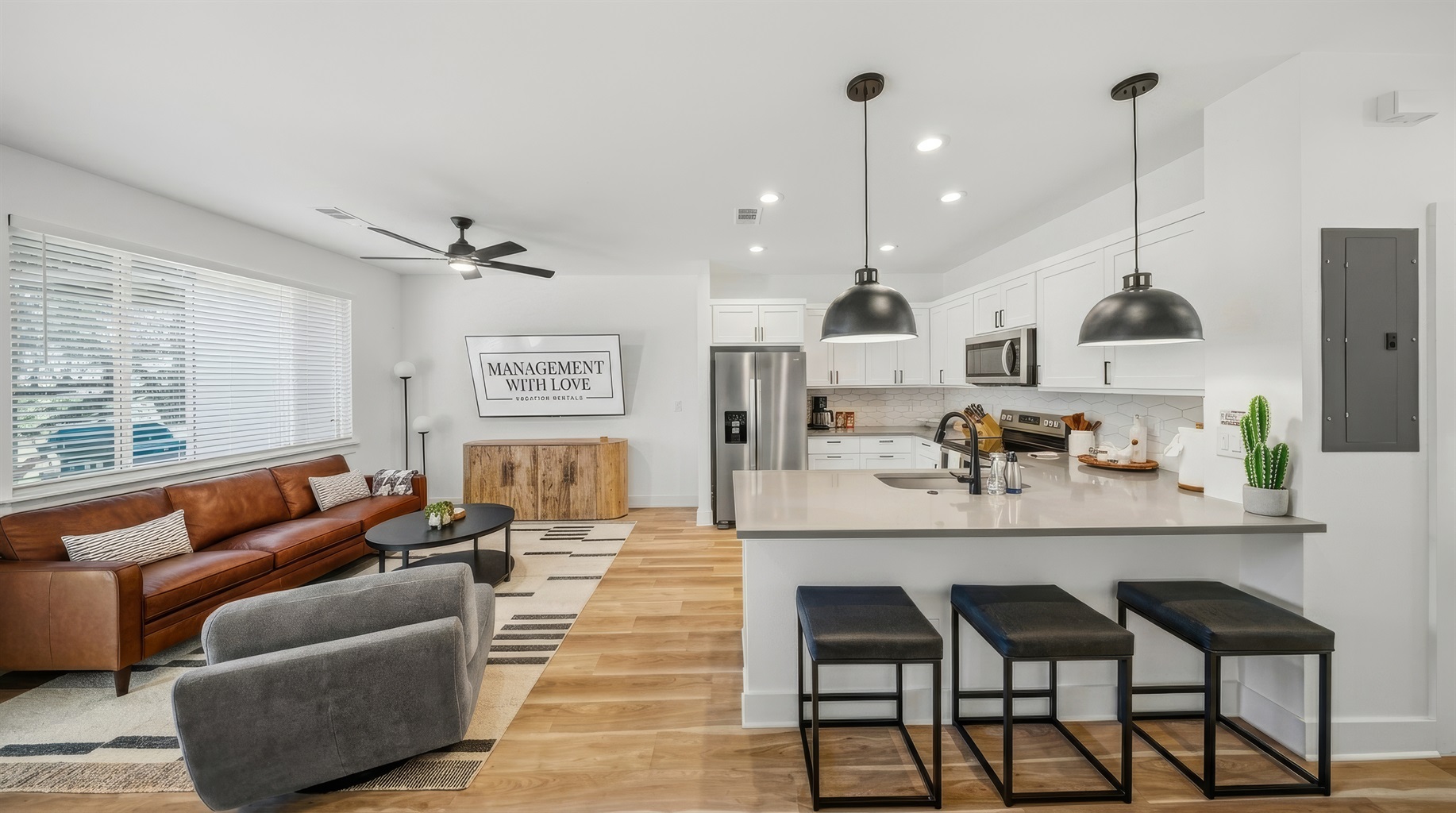Open concept living room with modern kitchen and island seating.