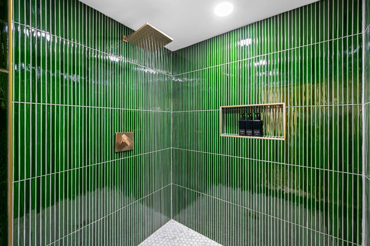 Spa Retreat: Revel in this luxurious shower, adorned in vibrant green tiles and sleek finishes!