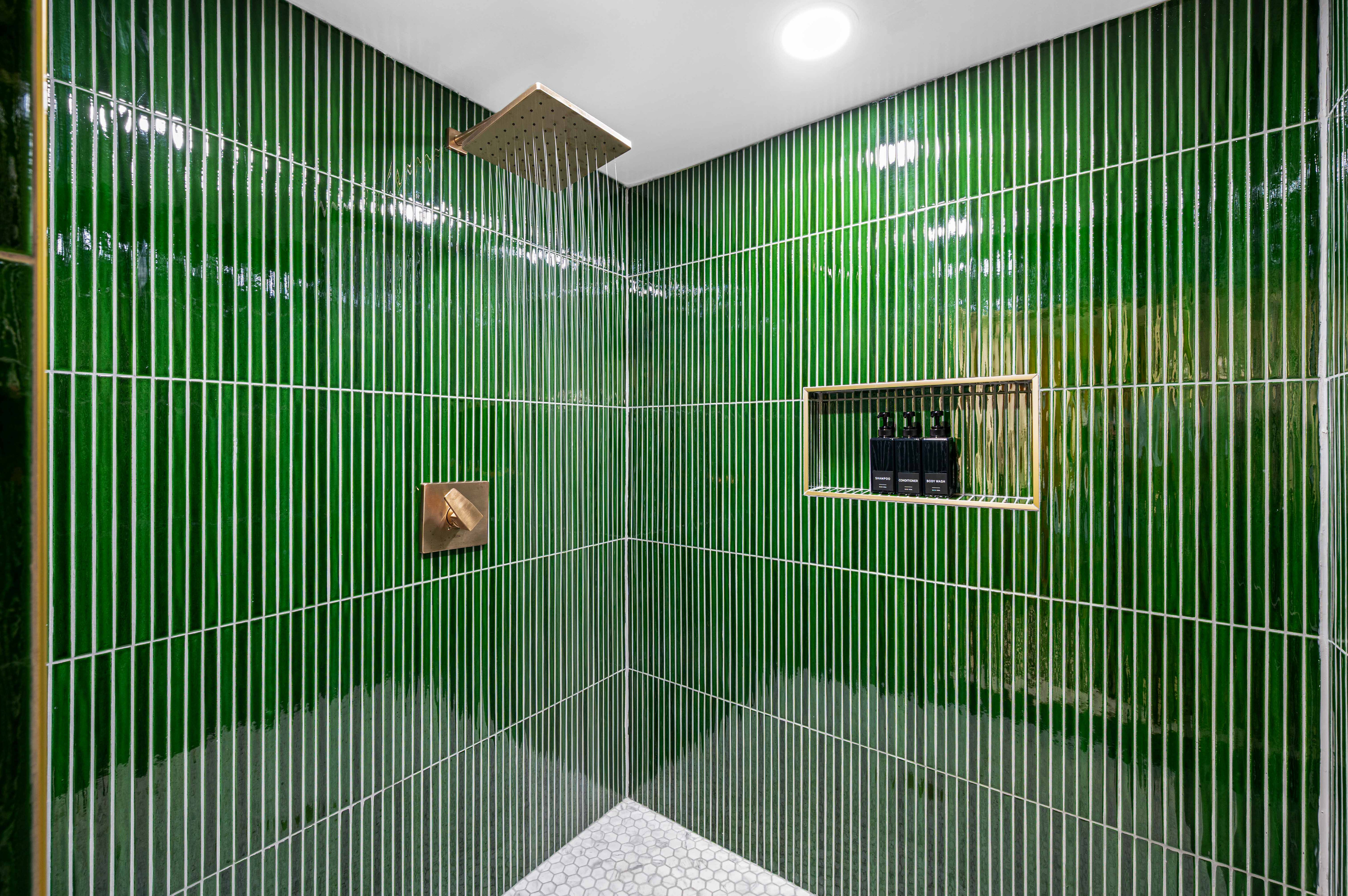 Spa Retreat: Revel in this luxurious shower, adorned in vibrant green tiles and sleek finishes!