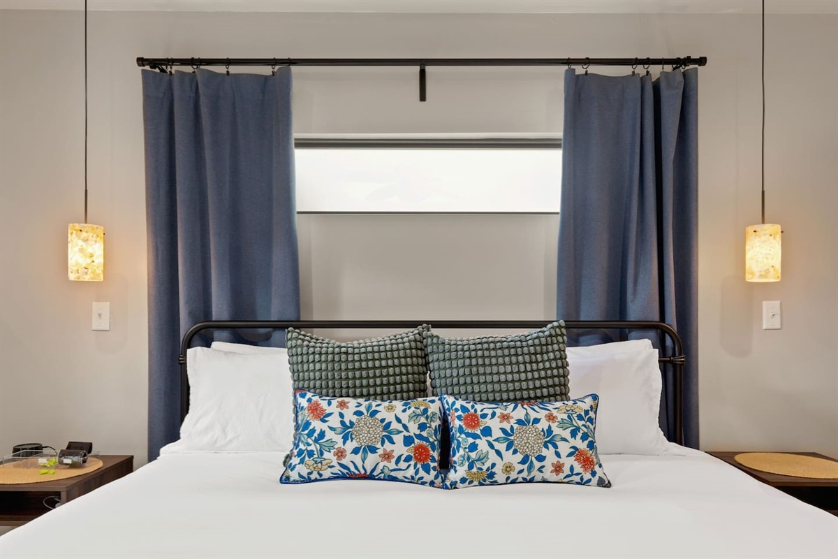 Peaceful primary suite with soft lighting and patio access ideal for slow mornings or restful nights.