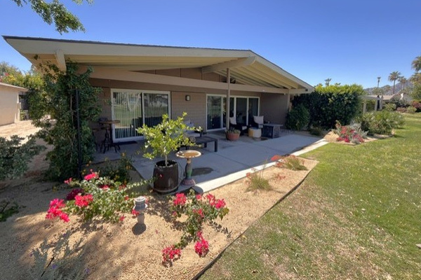 Covered patio with propane fire table, overhead fan, and soothing water feature.