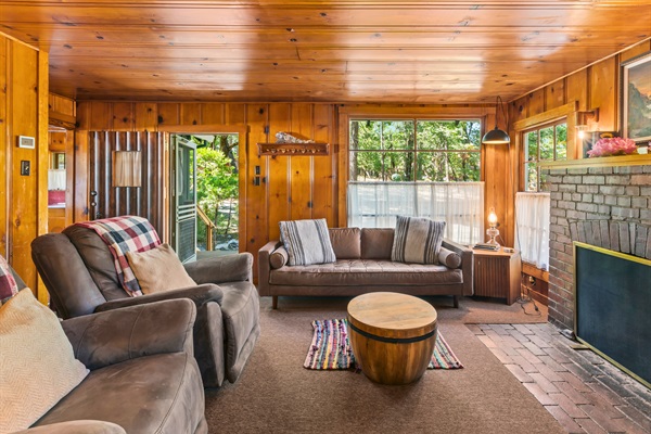Relax in the inviting living room with a fireplace, large windows, and plenty of space for gathering with family and friends.