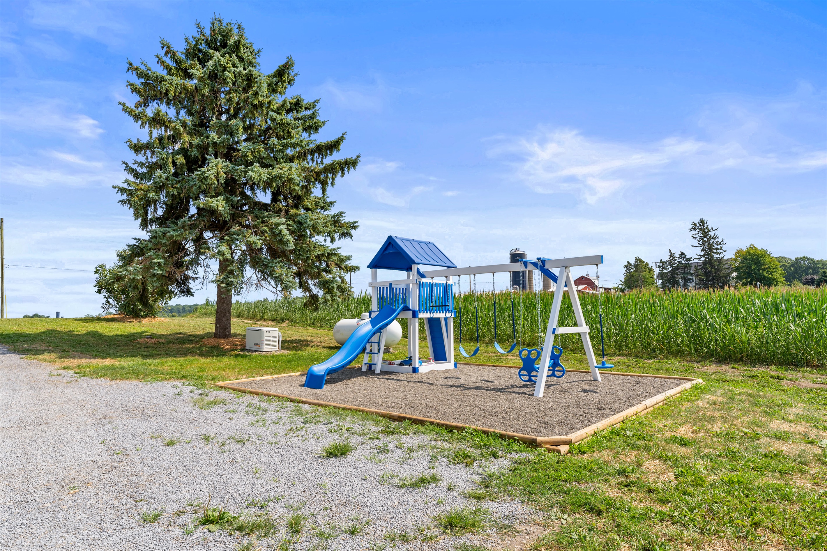 A bright outdoor playset with swings and a slide, perfect for kids to enjoy while parents relax nearby.