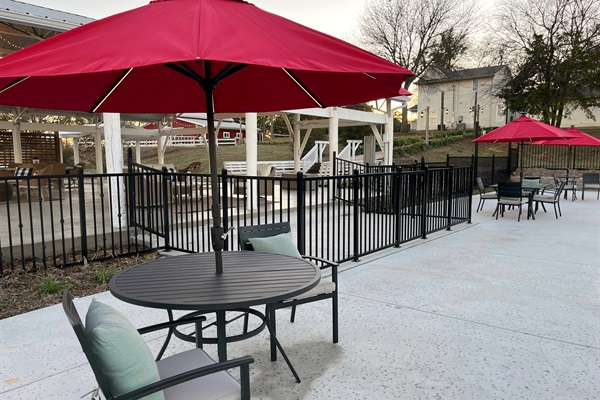 Seating behind the safety fence for poolside chats in the shade of an umbrella