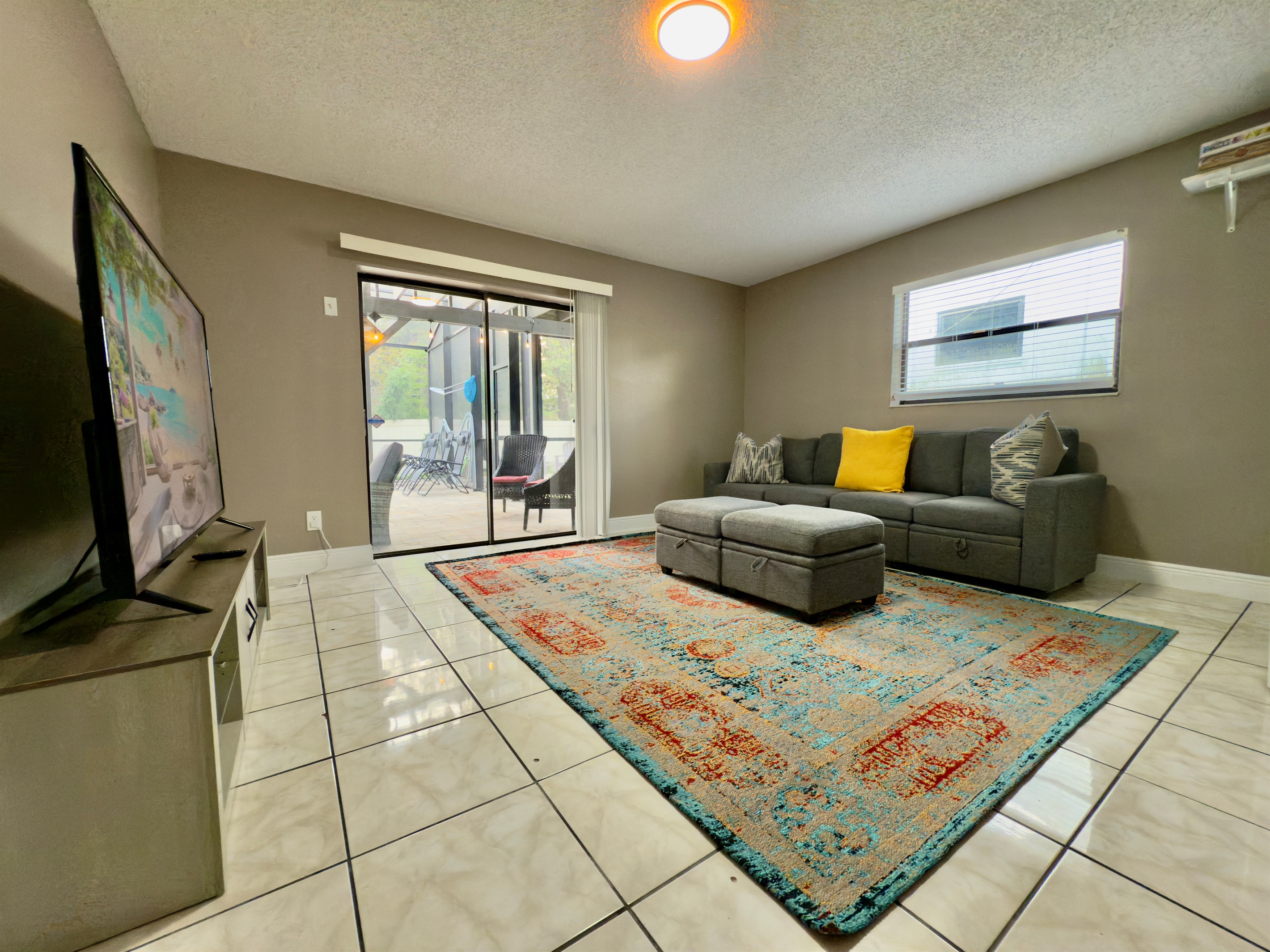 This spacious lounge-style living room is designed with comfort, color, and entertainment in mind.