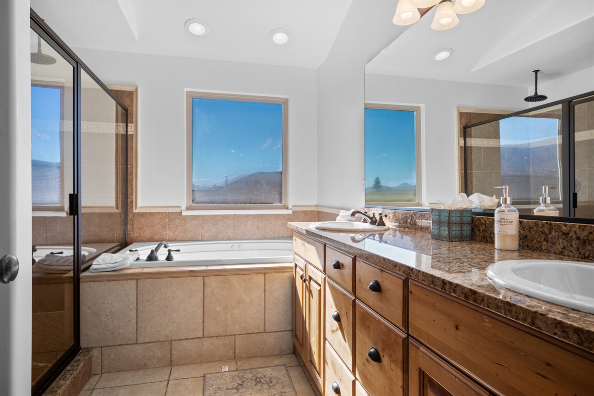 Features a walk-in shower, soaking tub, and double vanity with stunning mountain views.