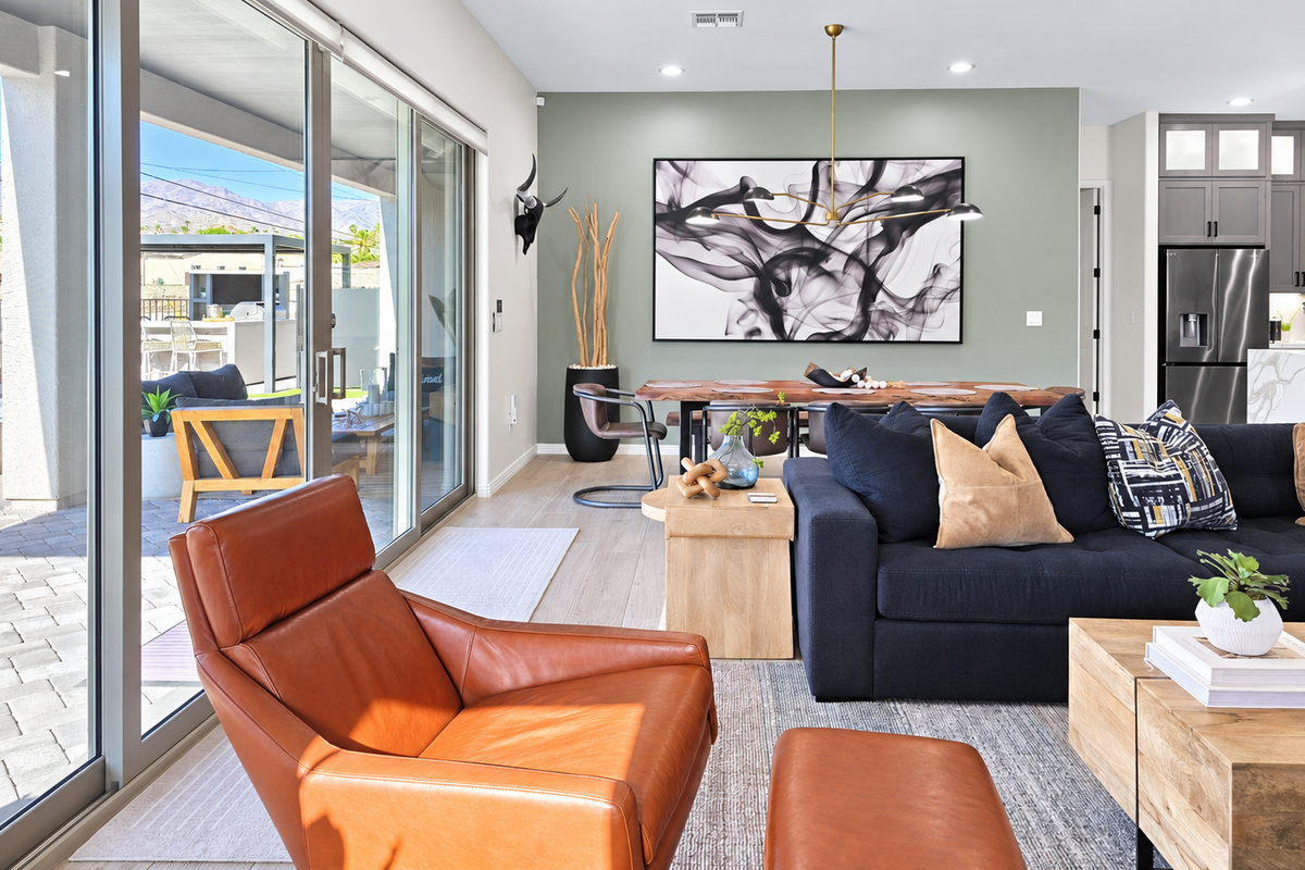 The living room flows seamlessly onto the outdoor patio, creating an effortless indoor-outdoor living experience.