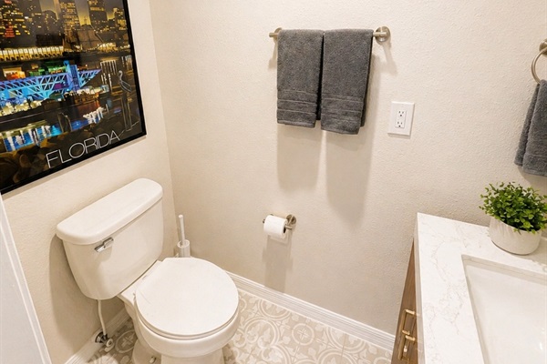 Clean and convenient half bath with a modern vanity, updated fixtures, and stylish tile flooring—perfect for guests and quick refreshes during your stay.