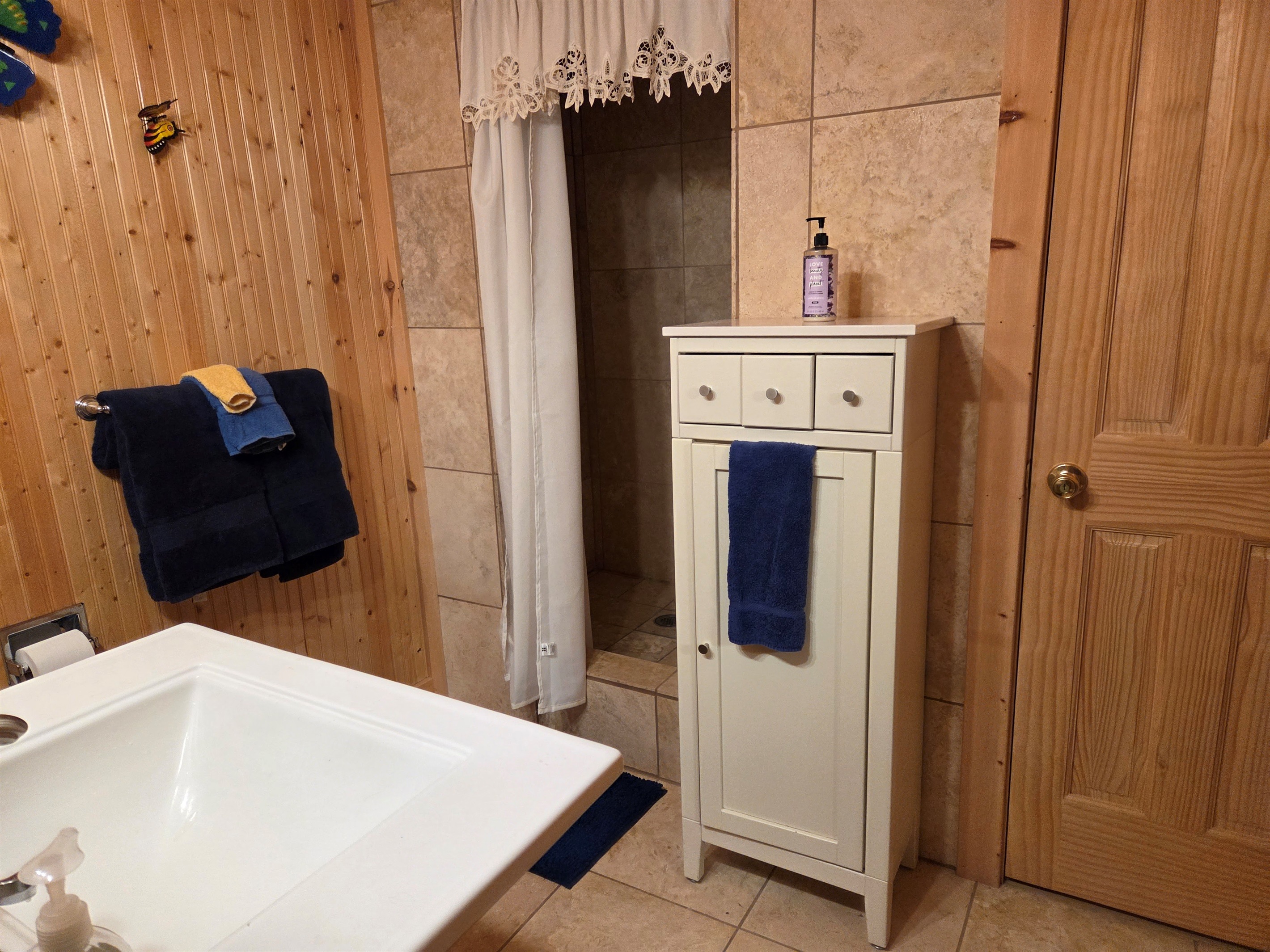 This ensuite bathroom for the master bedroom has storage and a jetted shower.
