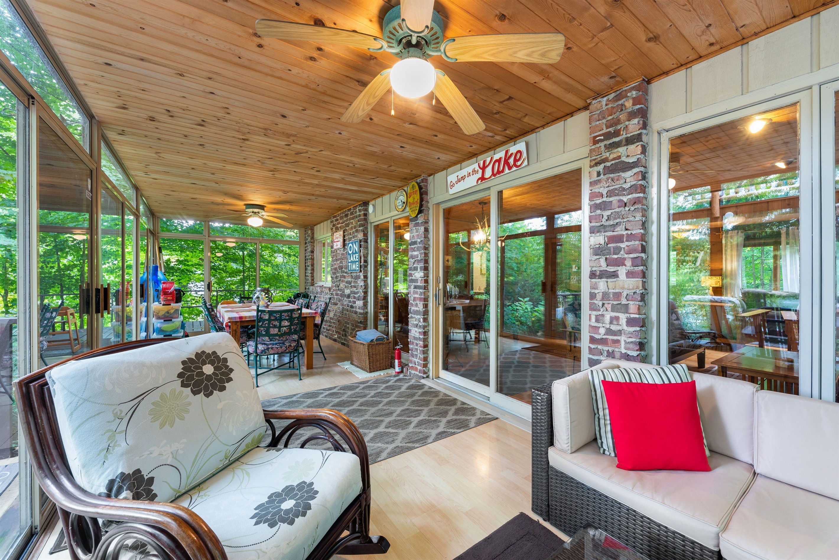 3 season room with sofa and comfy chair facing the lake