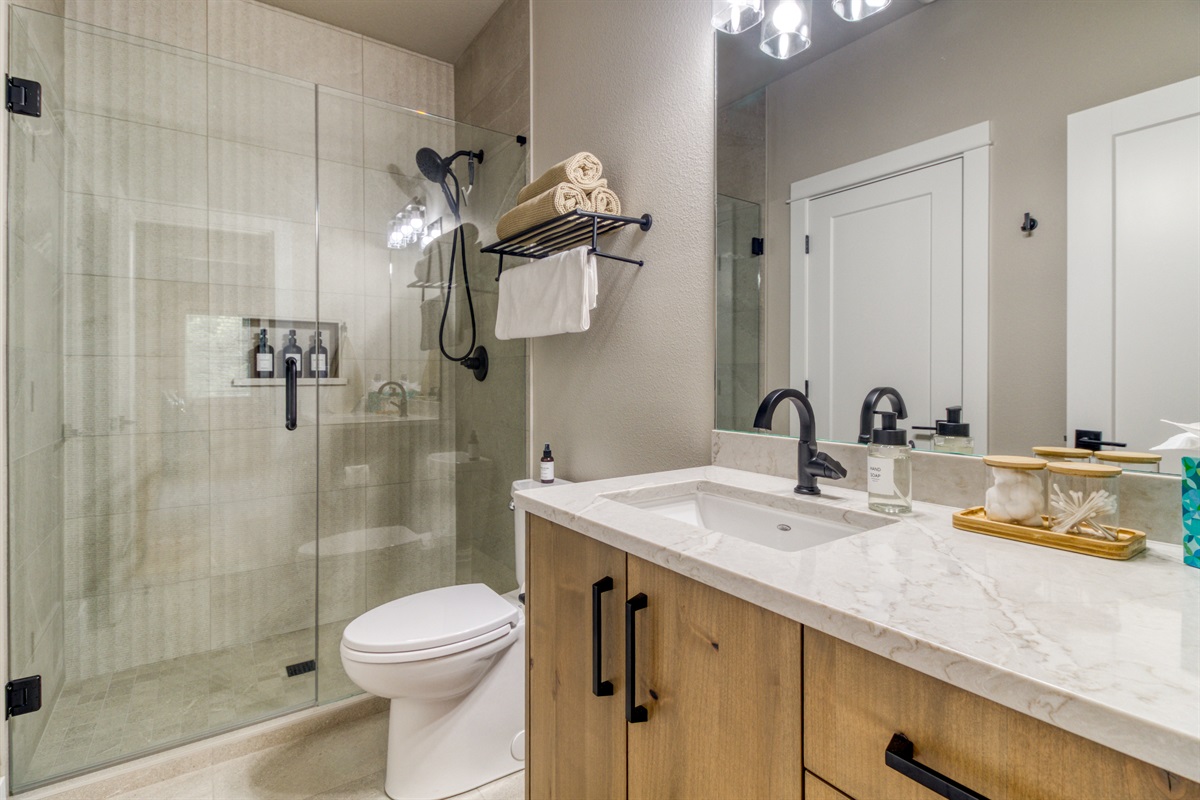 Full bath with walk-in tiled shower attached to the downstairs King Bedroom #2.