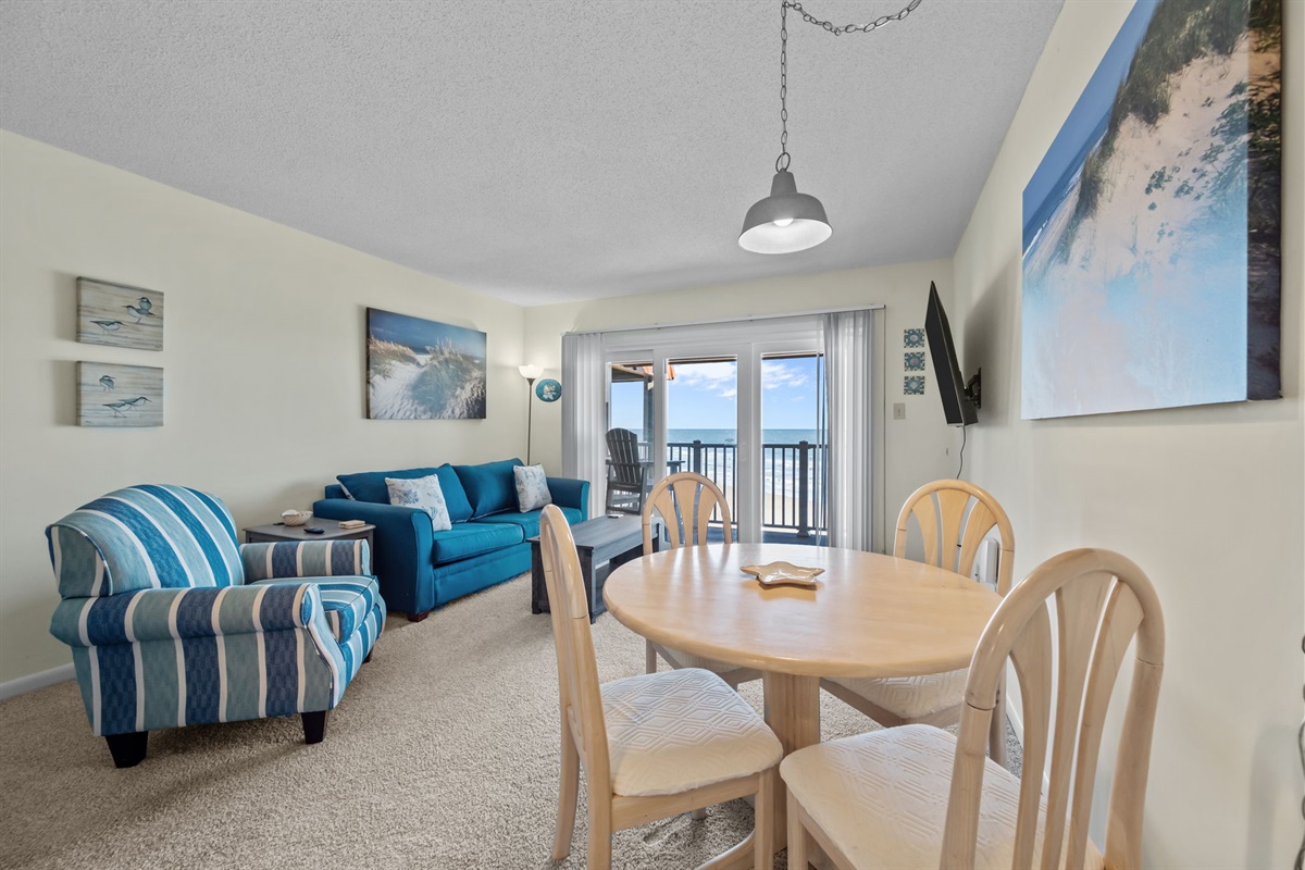 Dining area flows seamlessly toward the oceanfront balcony, keeping coastal views front and center during every meal
