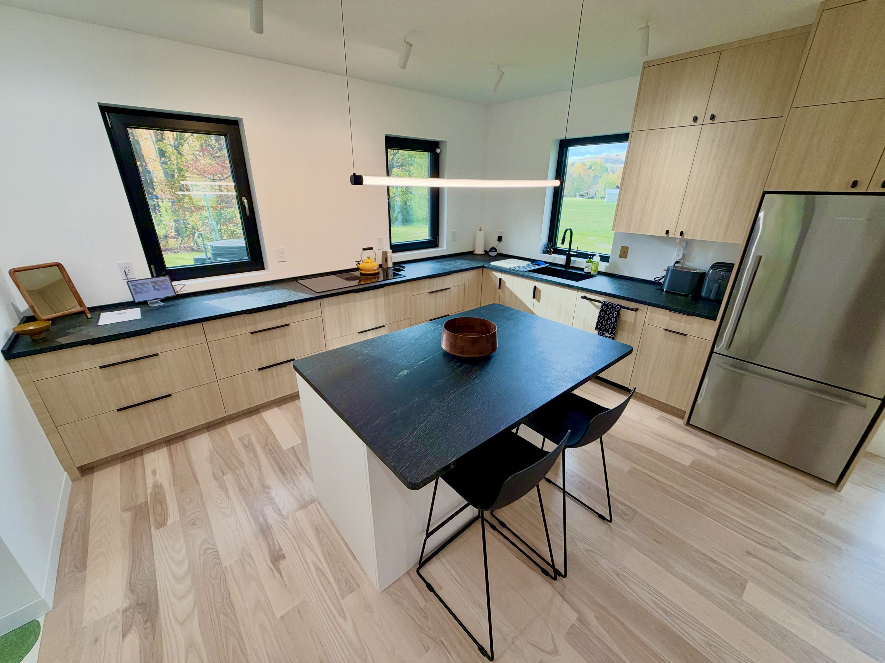 Kitchen includes full size oven, induction cooktop, microwave, air fryer, toaster, coffee maker, and more.