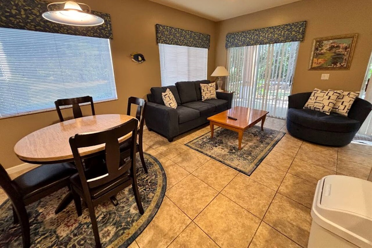 Bright living and dining space with comfortable seating, tile flooring, and a welcoming open layout.