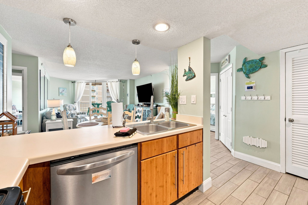 Welcoming entryway and kitchen bar area with pendant lighting and coastal decor to greet you upon arrival.