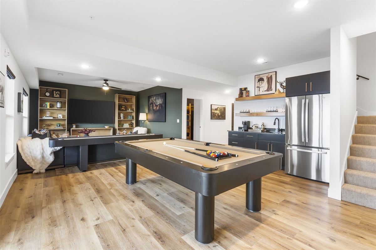 Lower level living area with pool table, shuffleboard, wetbar with fridge, and PS4