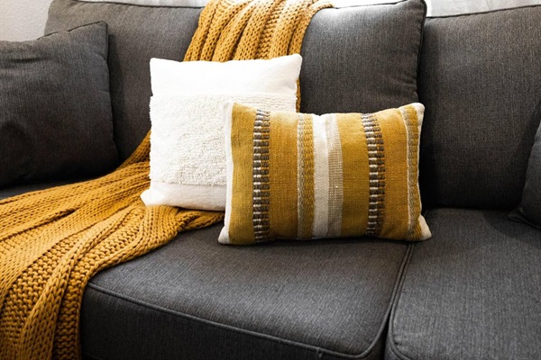 Attention to detail shines in this stylish living room, combining comfort and elegance with modern accents and plush pillows.