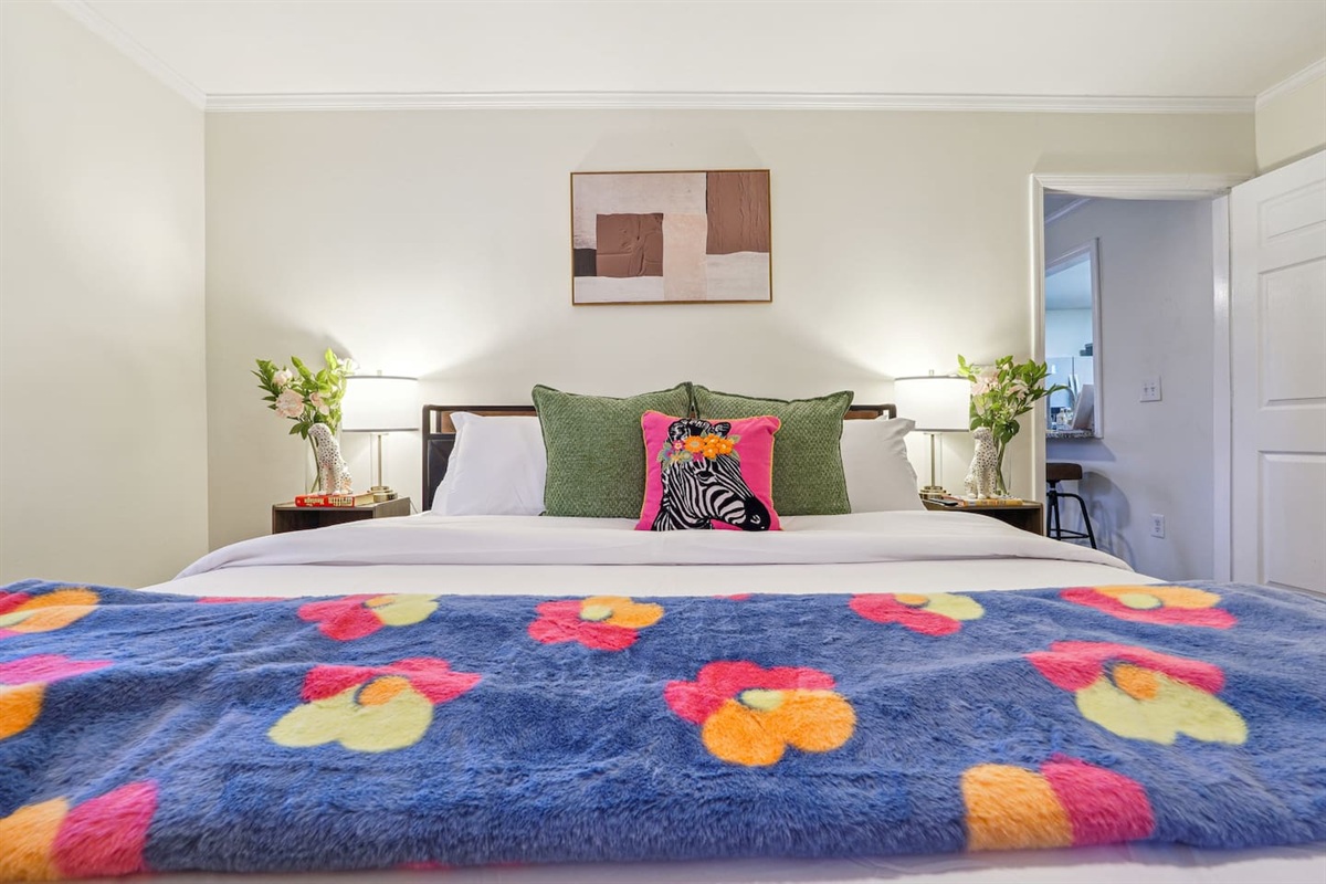 A cozy bedroom featuring a double bed, a bunk bed, a window, a bedside shelf with a lamp, and a TV — perfect for families or groups to relax and unwind.
