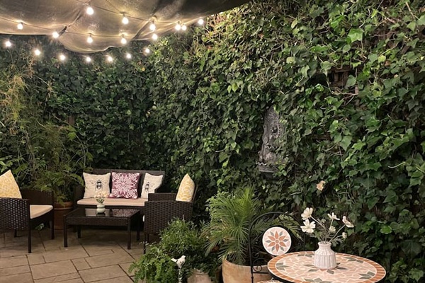 Peaceful backyard with warm string lights and fountains, perfect for relaxing in the evening.