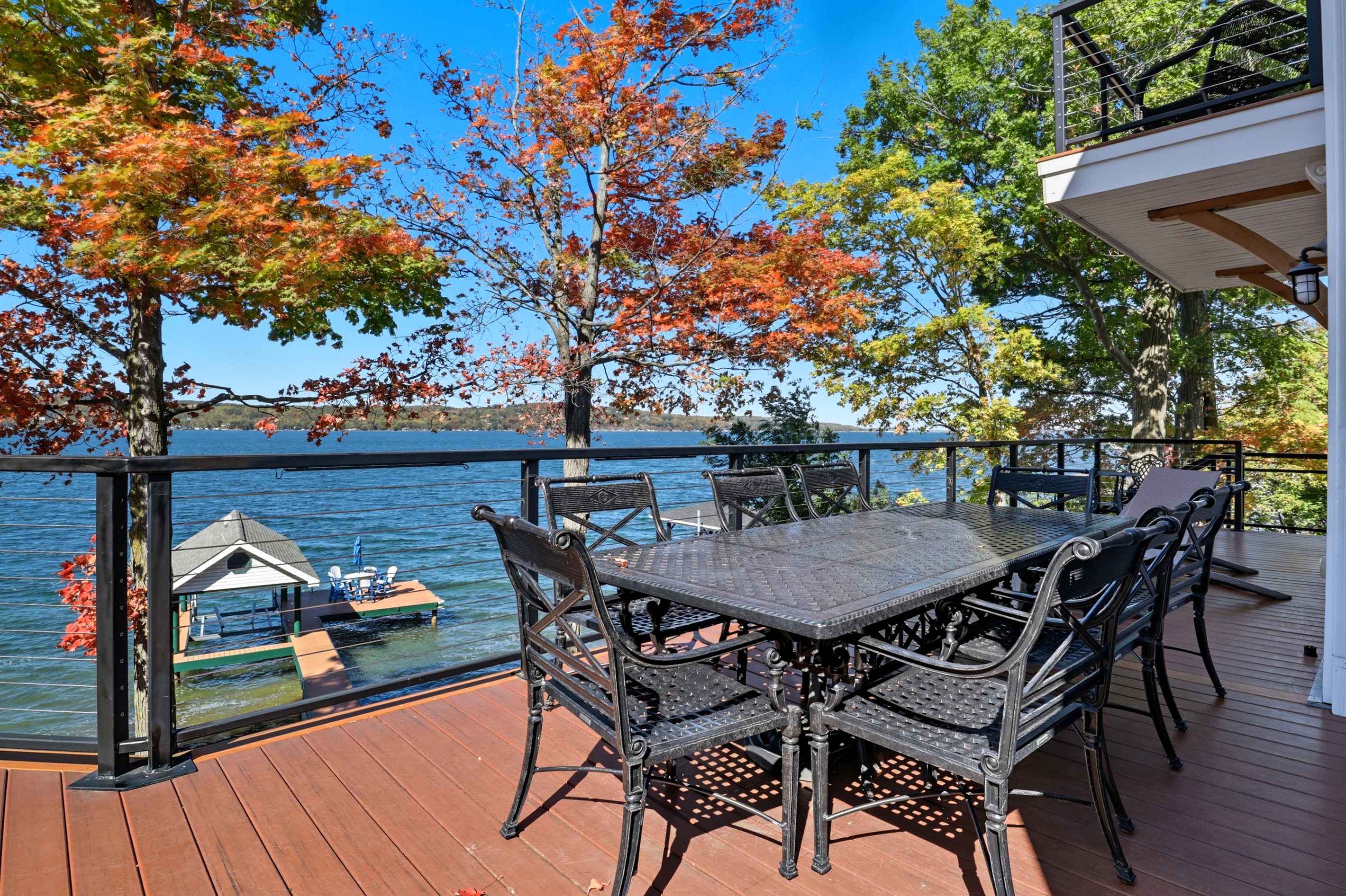 Spacious deck with multiple seating options by the lake.