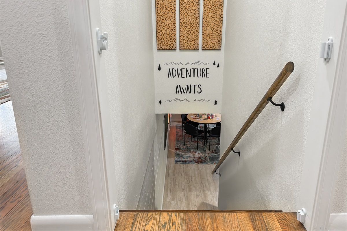 Head down the stairs to the lower level — game room, a reading nook and two more bedrooms waiting below.