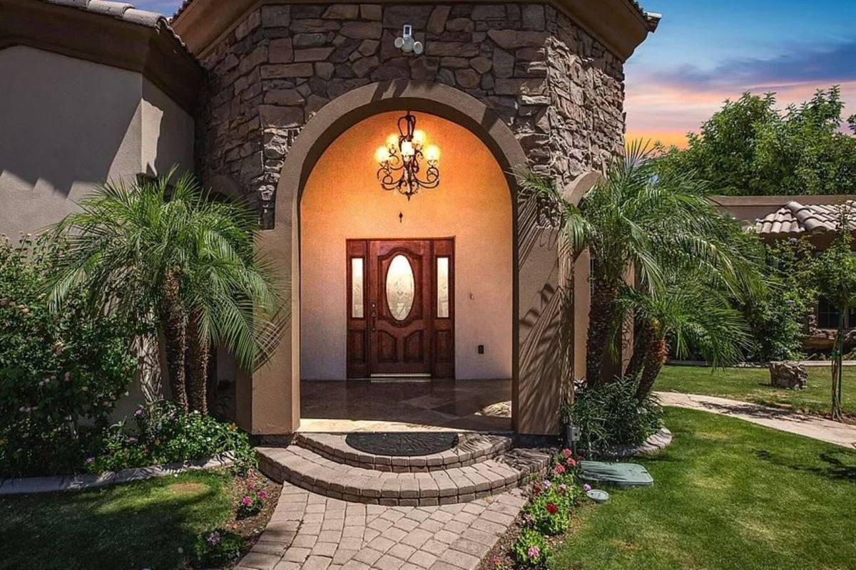 Make a grand entrance into your serene retreat, where lush landscaping, elegant stonework, and warm lighting set the tone for a relaxing stay.