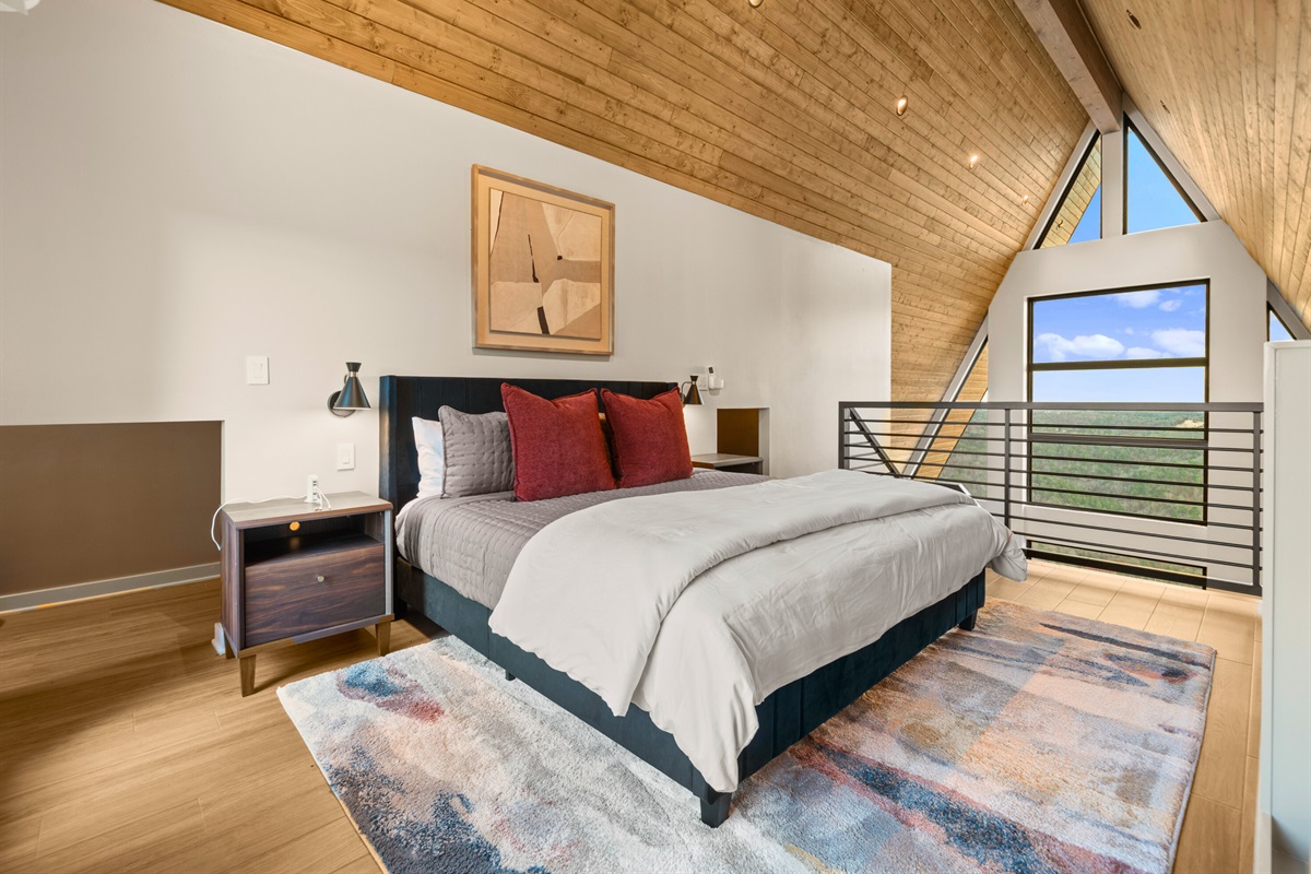 Another look at this bedroom highlights the comfortable bed and those gorgeous wood ceilings, giving it such a unique and cozy personality.