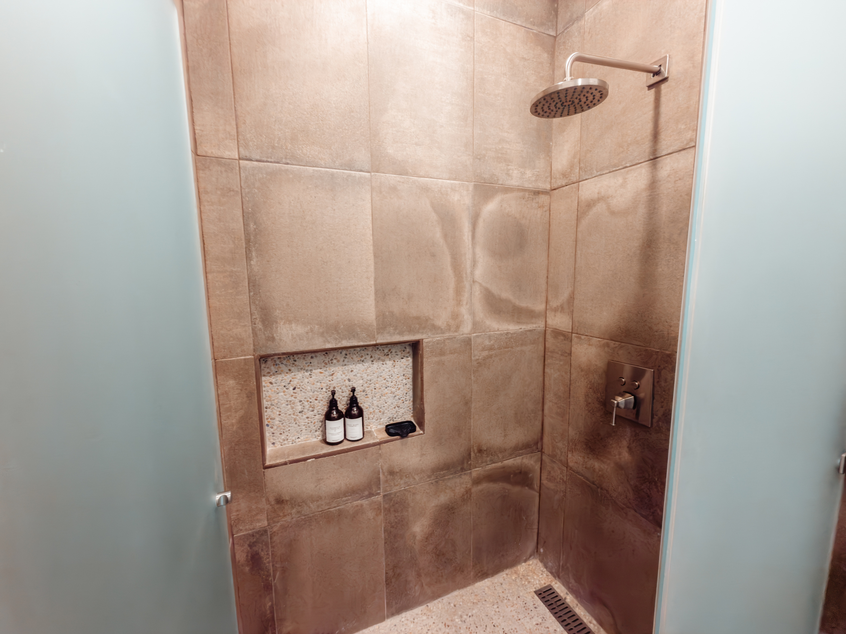 The shower. Ceramic tile, rain head, body wash and conditioning shampoo included