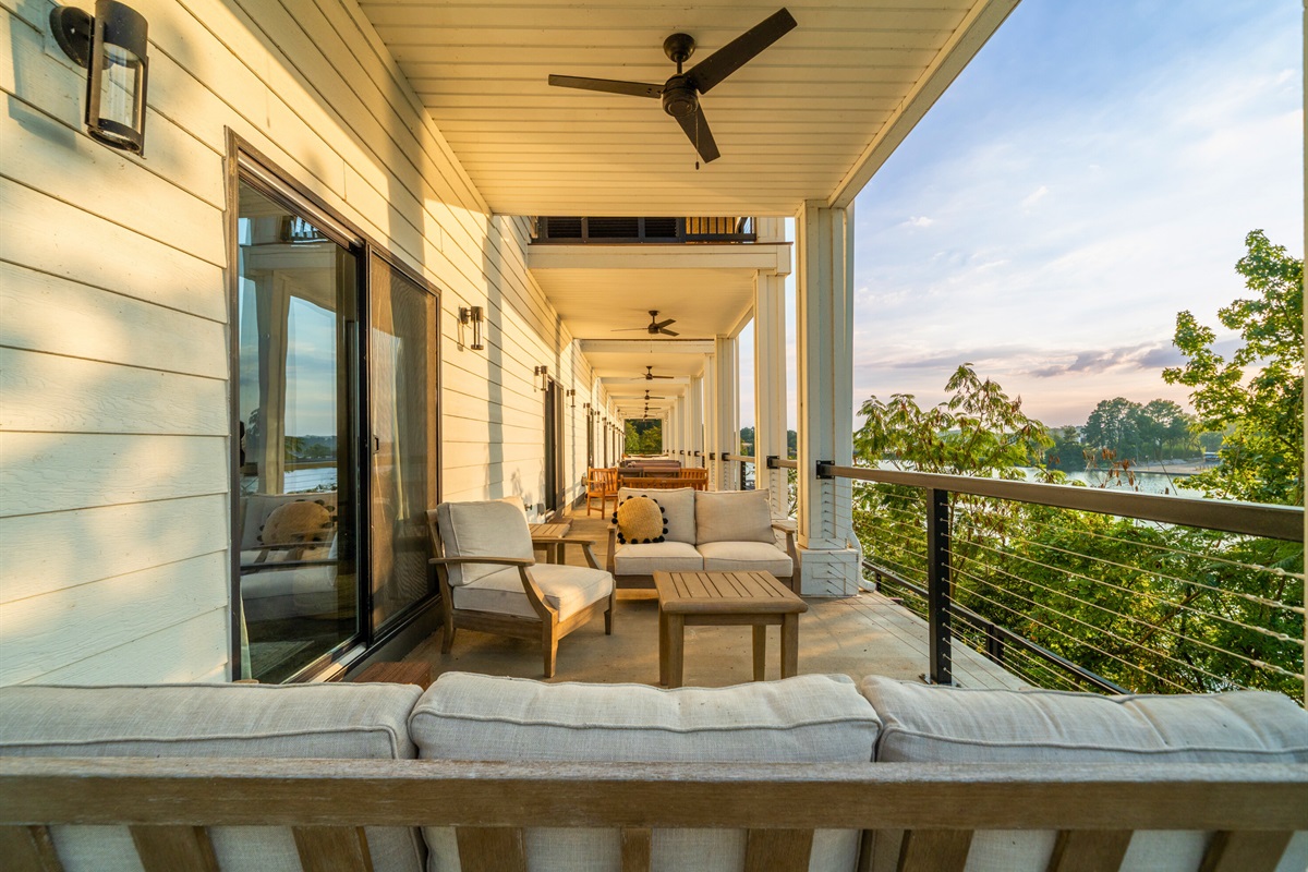 Spacious balcony with cozy seating and panoramic lake views&mdash;an entertainer&rsquo;s dream.