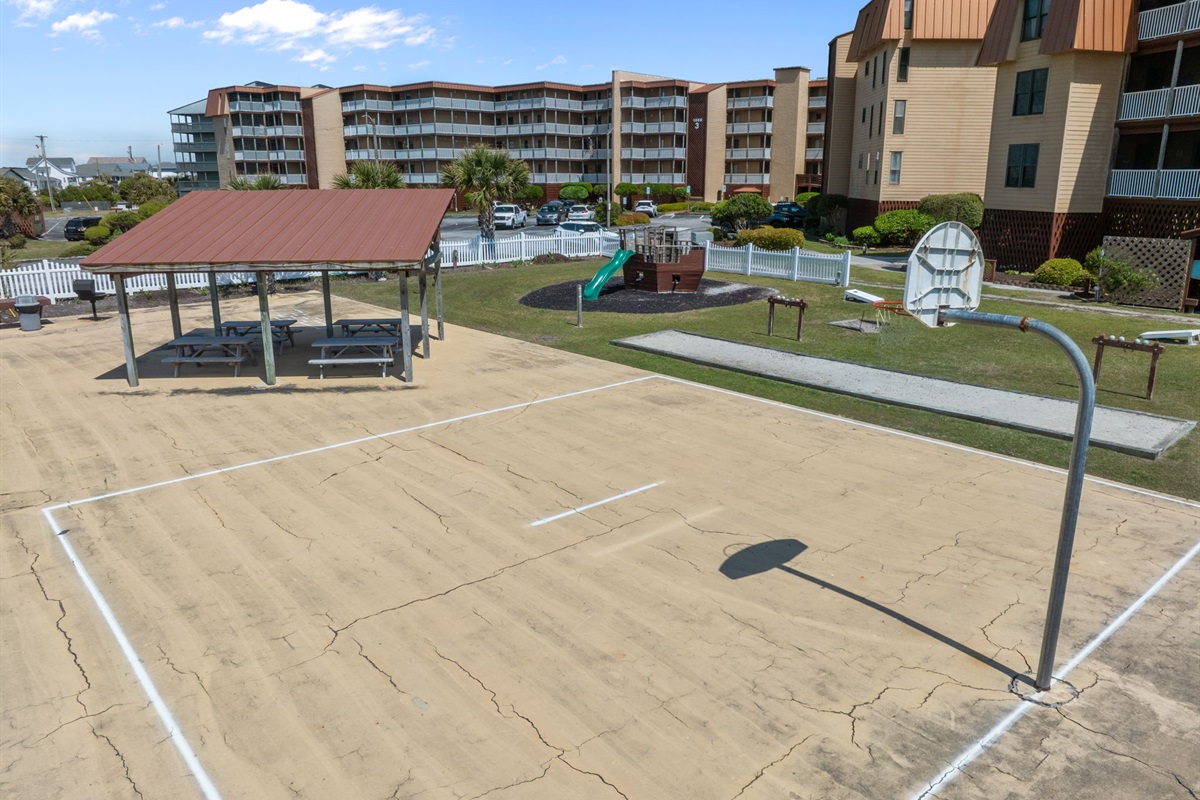 Fun outdoor area with basketball court, picnic seating, and play space