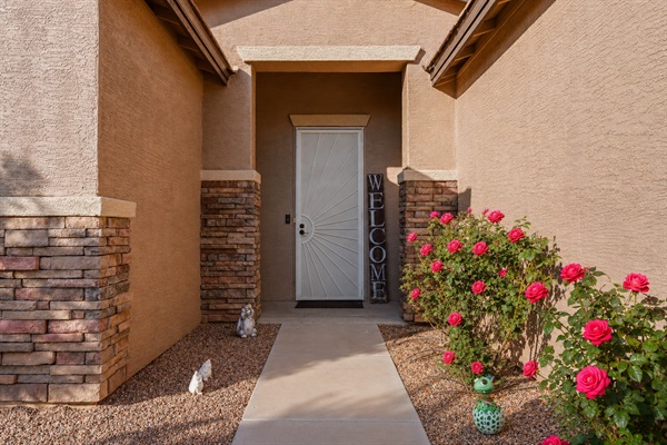 Welcoming entry with blooming desert roses and easy self check-in