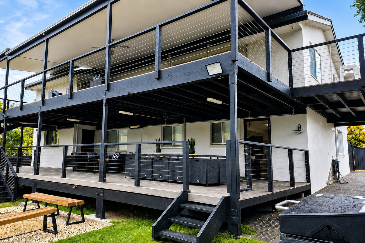 The back balcony view at Skye’s Beach House looks over the rear outdoor areas and the natural backdrop beyond the property.
