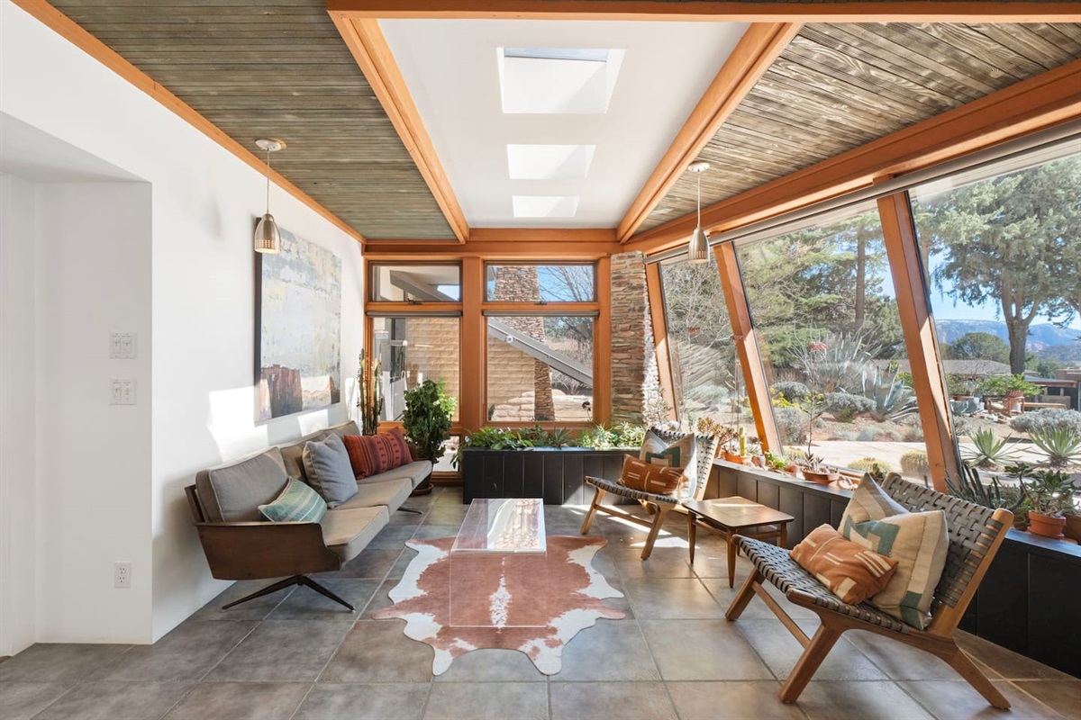 Bright sunroom with stunning desert views and stylish mid-century seating.