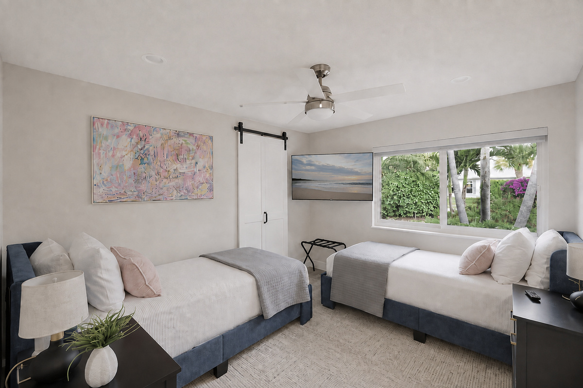 A bright twin bedroom gives kids, friends, or family members their own comfortable space with a TV, ceiling fan, and garden view.