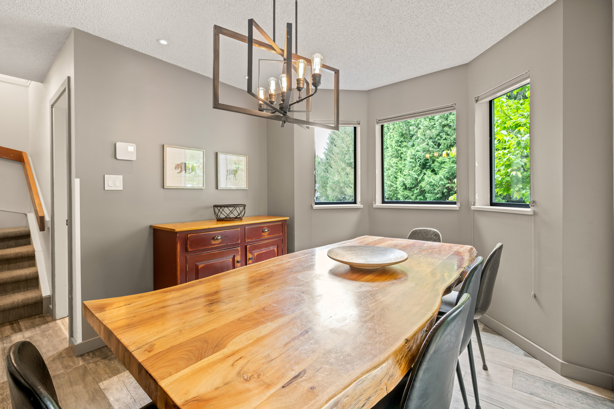 Dining table under a chandelier, next to the stairs to the bedrooms on the 2nd floor and the loft on the 3rd.