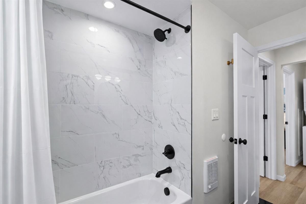 Relax in this spa-inspired bathroom with a sleek tiled shower, modern fixtures, and bright, clean finishes—perfect for unwinding after a long day.