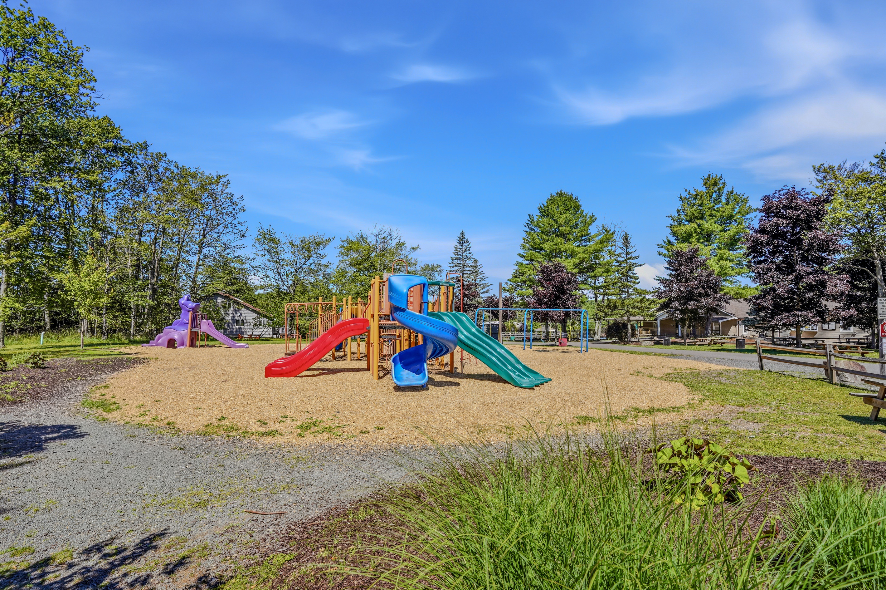  Community playground with colorful play structures on a sandy surface