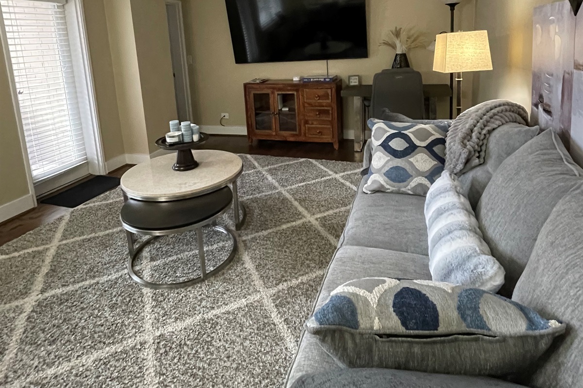 Bright living room w/ plush seating & TV, perfect for relaxing after a day out.