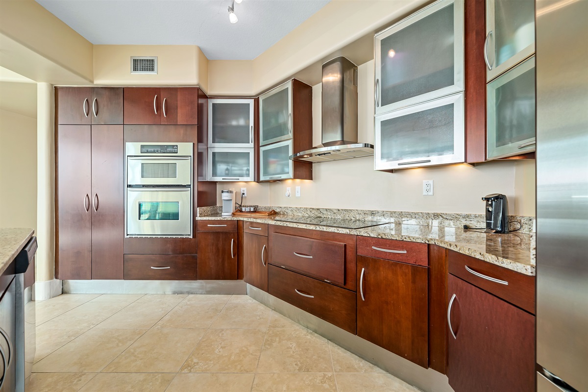 Gourmet kitchen with stainless steel appliances, granite countertops, and island seating. Open floor plan seamlessly connects to the living and dining areas.